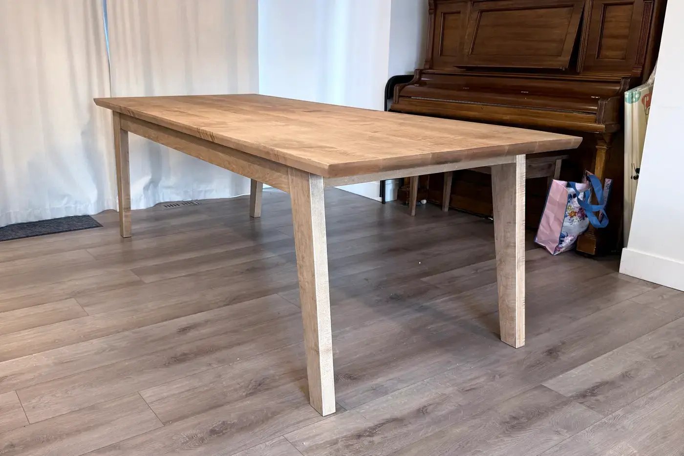 Custom solid maple dining table in Rubio Monocoat Castle Brown with tapered square legs, built for a Calgary family