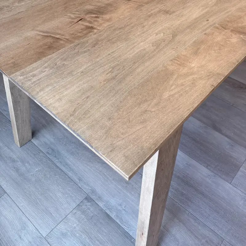 Close view of the solid hard maple top in Castle Brown, showing grain and eased edge